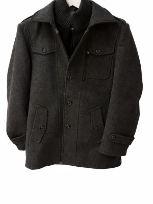 Mörkgrå ullrock med knappar - Snygg mörkgrå rock i ullblandning med klassisk krage, ribbad hög krage på insidan och flera fickor framtill. Stängs med knappar och har detaljer vid ärmslut. Perfekt för kyliga dagar och ger en clean look. Det går även att ta bort kragen på insidan   Det är en XL men sitter som en L/M