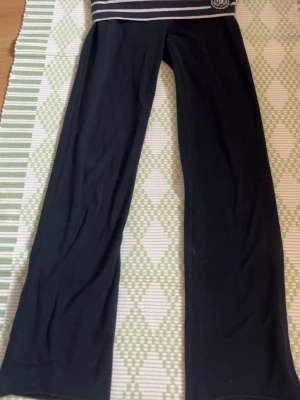 Mörkblå mjukisbyxor från Abercrombie - Mörkblå mjukisbyxor från Abercrombie & Fitch med bred, randig midjeresår i blått och vitt samt broderad logga framtill. Byxorna har utsvängda ben och är gjorda i mjukt bomullsmaterial💕