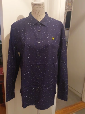 Skjorta fr Lyle&Scott - .Mörkblå i botten vita och grå små prickar från Lyle &Scott. 