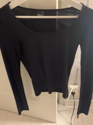 Svart långärmad topp Gina Tricot - Bra kvalitet och inte använd mycket. Ärmarna har en slits och den har bra passform