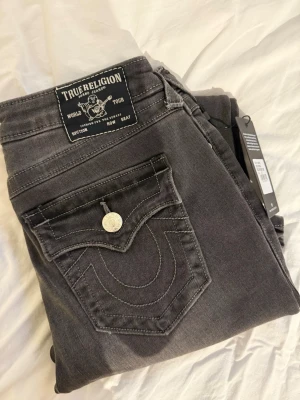 True Religion jeans - Säljer dessa nya gråa/svarta jeans från true religion! ”Becca mr boot flap”, storlek 27, passar både 26 och 27. Otroligt snygga!! (Nypris 1299kr) 