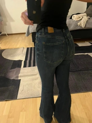 Mörkblå bootcut jeans från bershka - Säljer ett par mörkblå bootcut jeans från bershka. Jeansen har en snygg tvätt och lätt utsvängda ben, perfekta till sneakers eller boots.