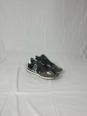 Philippe Model - Philippe Model sneakers i en grå camo-färg, skorna är i riktigt bra skick och är i storlek 45, men passar 44. Vid frågor eller funderingar är det bara att höra av sig!