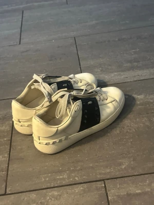 Vita sneakers från Valentino - Säljer ett par vita sneakers från Valentino med svarta nitar på sidan.  Skorna är i mycket fint skick. Säljer skorna då gör vi testa något nytt och då kan det vara bra att skorna kommer till användning för någon annan. hör av dig av minsta intresse. Priset går att diskuteras. Box och allt tillkommer också. 