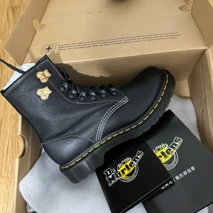 Svarta boots från Dr. Martens - Snygga svarta boots från Dr. Martens i skinn med klassisk gul söm runt sulan. Skorna har snörning och metallöglor för en robust look. Perfekta för en edgy stil.