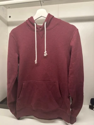 Schysst Hoodie Peir One - Snygg vinröd hoodie med klassisk känguruficka och vit dragsko i huvan. Mjuk bomullskänsla och ribbade muddar vid ärmslut och nederkant. Perfekt för en chill och avslappnad stil. Super schyst och super skön. Har du några frågor så skriv gärna, svarar snabbt!🙌🔥💸