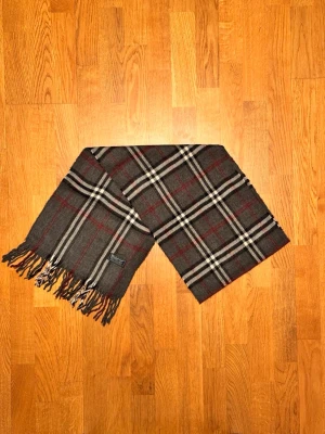 Grå Burberry halsduk - Säljer en grå halsduk från Burberry. Halsduken är i gott skick och är gjord i 100% kashmir. Var inte rädd för några frågor. Pris diskuteras inte!