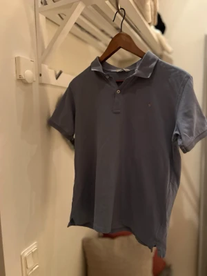 Blå piké t-shirt från Gant - Klassisk blå piké t-shirt från Gant med krage och två knappar framtill. Tillverkad i mjuk bomull och har korta ärmar. Perfekt för en stilren och avslappnad look.