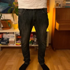 LS - Snygga mörkblå jeans med raka ben och kontrastsömmar. Klassisk femficksmodell och normal midja. Jeansen har metallknappar och nitar samt diskreta detaljer på bakfickorna. Perfekta för en avslappnad och stilren look.