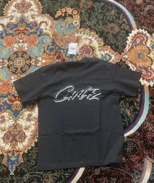 Svart Corteiz t-shirt med logga - Svart t-shirt från Corteiz i storlek small med stor vit logga tryckt över bröstet. Klassisk rund hals och korta ärmar. Materialet är mjuk bomull som känns skönt mot huden. Perfekt för dig som gillar streetwear och vill sticka ut med en fet logga.