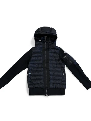Moncler Cardigan  - Svart pufferjacka från Moncler med huva, quiltad front och stickade ärmar. Jackan har dragkedja framtill och på ärmen, samt Moncler-logga på vänster arm. Materialmix av polyester och stickad textil ger en schysst kontrast.  