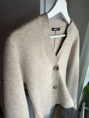 Beige kofta från Gina Tricot - Snygg beige kofta från Gina Tricot med två stora knappar framtill. Storlek xs, 