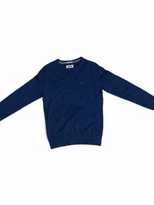 Blå stickad tröja Tommy Hilfiger - Snygg marinblå stickad tröja från Tommy Hilfiger med diskret logga på bröstet. Tröjan har v-ringad hals och långa ärmar, samt ribbade muddar vid ärmslut och nederkant. Perfekt för dig som gillar klassisk stil med en modern touch.