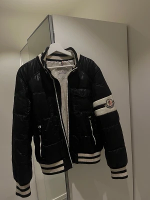 Svart Moncler pufferjacka med vita detaljer - Svartvit jacka från moncler! Strl M inga defekter!