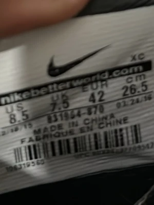 Nike fotbollsskor röd/svart/gul strl 42 - Säljer ett par Nike fotbollsskor i storlek 42 med en snygg röd och svart randig design och stora gula swoosh-loggor. Skorna har platt sula med dobbar för bra grepp på planen och är tillverkade i syntetmaterial. Perfekt för dig som vill sticka ut på fotbollsplanen.