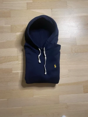 Marinblå Ralph lauren hoodie - Skicket är nästan som om den vore helt ny! Nypris ligger på över 2000kr och jag säljer den endast för 899! Vid minsta fundering är det bara att skriva till mig, mvh Partille closet