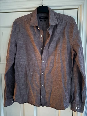 Riley linneskjorta - Gråbrun ursnygg och populär Riley linneskjorta i storlek m säljes. Inga hål eller fläckar och mycket sparsamt använd. Tveka inte vid minsta fråga eller fundering🤩
