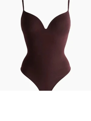 Vinröd Body - Säljer denna vinröda body från H&M helt oanvänd med prislapp kvar. Jätte fin och passar många storlekar då den är stretchig. 