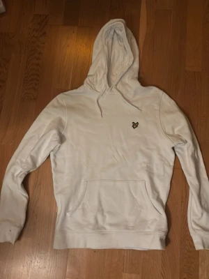 Lyle & Scott  - Snygg vit hoodie från Lyle & Scott (Organic). Klassisk modell med huva med loggan på bröstet.