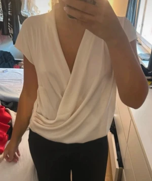 Topp från Mango - Snygg omlott topp från Mango. Sparsamt använd. Passar S-L beroende hur du vill den ska sitta. Vit/offwhite