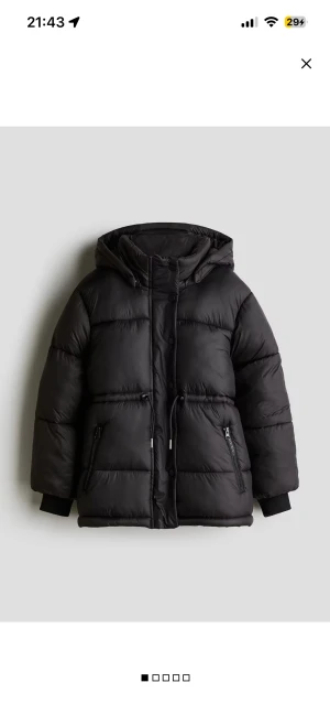 Svart pufferjacka med huva - Säljer en svart pufferjacka med huva och dragkedja samt knappar framtill. Jackan har snörning i midjan och två fickor. Jackan är långärmad med ribbade muddar vid ärmslut. Perfekt för kalla dagar. Storlek 164 men skulle säga Xs-S!