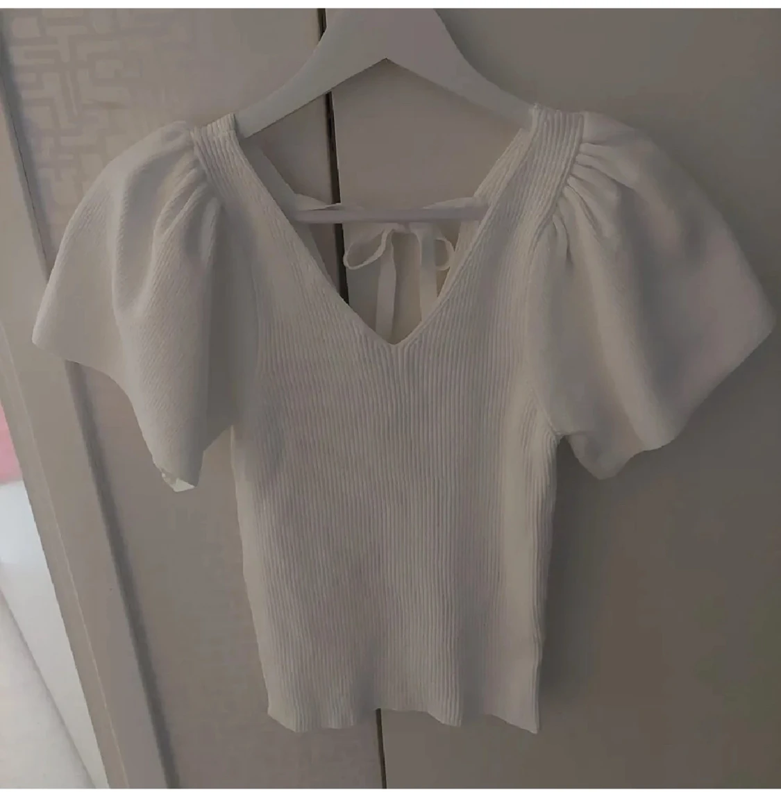 Vit ribbad topp från ONLY med puffärm och knytning i ryggen 