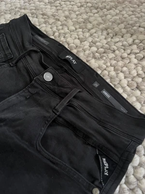 Svarta Replay Anbass Hyperflex Jeans Slimfit - Stilrena och bekväma i klassisk svart tvätt. Sitter snyggt och har bra passform utan att vara för tighta. Använda men i mycket fint skick utan fläckar eller defekter.  Modell: Ambassador Färg: Svart Storlek: W29, L30 Passform: Slim fit Skick: Fina, sparsamt använda