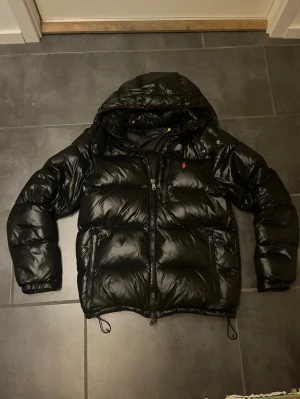 Polo Ralph Lauren Jacka - Säljer min Ralph Lauren pufferjacka i storlek M då jag köpt annan jacka. Passar runt 170 - 190cm. Fungerande qr-kod samt kvitto finns. Sydd i nacken men syns minimalt och inget man märker av (Bild 7) men därav priset. Kan gå ner pris vid smidig affär 🙌 Bara höra av sig vid frågor eller fler bilder🤝