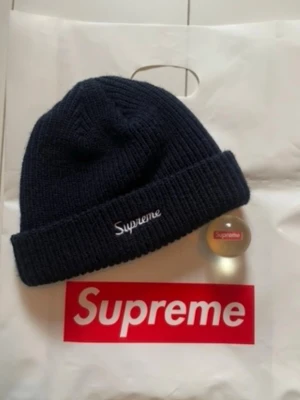 Supreme Beanie Mörkblå  - Supreme Beanie med broderad logga framtill. Från Fall/Winter kollektionen 2018 använd vid 3 tillfällen, sen dess har den lagt i byrån inuti påsen. så den är som ny. Gummiboll ingår ej den har jag slarvat bort 