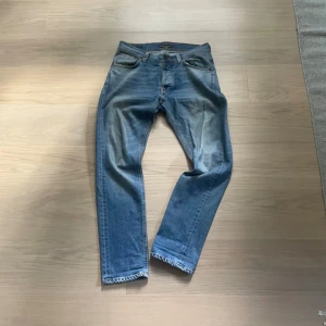 Blå jeans från Nudie Jeans - Säljer ett par klassiska blå jeans från Nudie. Finns en skada, se sista bilden.