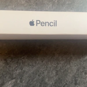 Apple Pencil (1st Generation) - Apple Pencil 1st generation i originalförpackning, kompatibel med flera iPad Pro- och iPad-modeller. Pennan och förpackningen ser ut att vara i mycket gott skick, inga synliga skador eller slitage. Perfekt för kreativt arbete, anteckningar och precisionsritning.