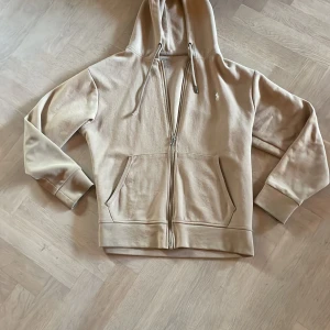 Beige hoodie från Polo Ralph Lauren - Snygg beige hoodie från Polo Ralph Lauren, den är använd men fortfarande i bra skick, fråga om det finns funderingar