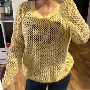 Gul stickad tröja från Pieces - Säljer en ljusgul stickad tröja från Pieces i storlek S. Tröjan har ett öppet, nätliknande mönster och är långärmad med ribbade muddar vid hals och ärmslut. Perfekt för lager-på-lager och ger en chill vibe till din outfit.