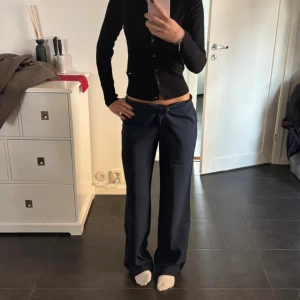 Mörkblå lågmidjade vida kostymbyxor från NA-KD - Säljer ett par mörkblå byxor från NA-KD i storlek 34. Byxorna har låg midja, vida ben och snyggt fall. Perfekta för en chill och trendig höstlook. Endast provade då de va lite stora för min smak!