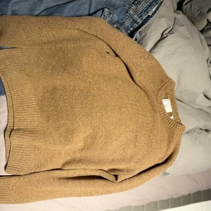 Brun ul tröja från bläck - Snygg brun ul tröja från bläck med rund hals och ribbade muddar vid ärmslut och nederkant. Tröjan är mjuk och har en klassisk, enkel design som funkar till jeans eller chinos. Perfekt för dig som gillar stilrena plagg med lyxig känsla. pris går att diskutera.