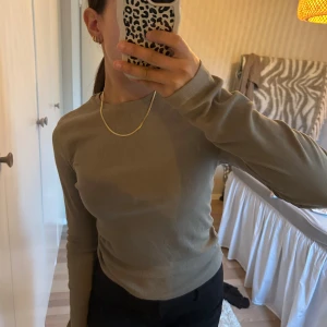 Beige ribbad långärmad tröja - Säljer en stilren beige långärmad tröja i ribbat material från BikBok. Perfekt att matcha med jeans eller kostymbyxor för en clean och enkel look.