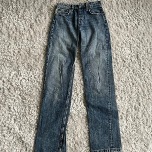 Blå raka jeans från Zara - Klassiska blå jeans från Zara med raka ben och normal passform. Jeansen har fem fickor, bälteshällor och stängs med dragkedja och knapp. Tillverkade i slitstarkt denimtyg som ger en tidlös look.