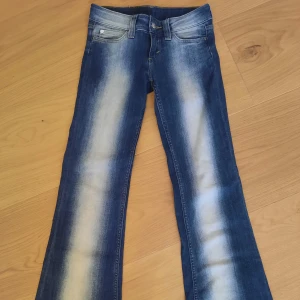 Cheap Monday blå bootcut jeans - Säljer ett par blå bootcut jeans från Cheap Monday med tydliga slitningar och ljusa partier framtill och baktill. Dom är lågmidjade och är stretching. Skriv gärna om du har några frågor💕