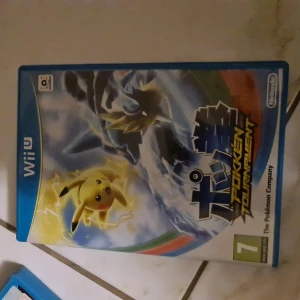 Pokkén Tournament (Wii U) - Pokkén Tournament till Wii U är ett actionfyllt Pokémon-fightingspel där du kan slåss som dina favorit-Pokémon. Omslaget och fodralet är i fint skick, inga synliga skador eller slitage. Perfekt för samlare eller Pokémon-fans som vill ha en ny spelupplevelse.