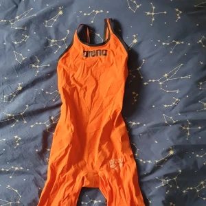 Tävlingsbaddräkt, arena, powerskin, uk26. - Tävlingsbaddräkt från Arena storlek uk26. Använt men bra skick. Lite trådar vid benslut, se sista bilden. Arena -märket på benet syns inte längre men stora på bröstet samt Fina-märket är väl synliga! "Förvaringsbag" från Arena medföljer. Säljer då dottern gått över till annat märke. 