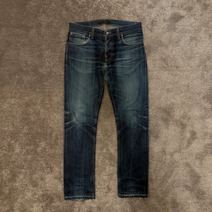 Nudie Jeans  - Nudie Jeans Dry Selvage med en riktigt vacker fade❕Lagningen som visas på andra bilden syns knappast när man har på sig dom. Storlek 32:32 | Modell: Grim Tim | Hör av dig vid minsta fråga!