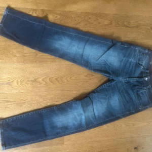 Levis 502 straight fit - Levi’s 502 jeans. Blå jeans med klassisk straight fit och diskretas slitningar på låren. 