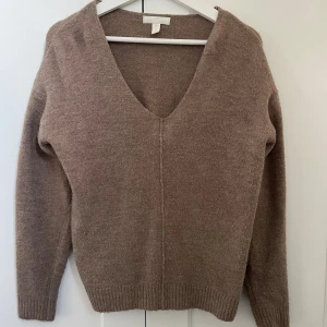 Ljusbrun stickad v-ringad tröja H&M - Mysig ljusbrun stickad tröja från H&M med djup v-ringning och lång ärm. 
