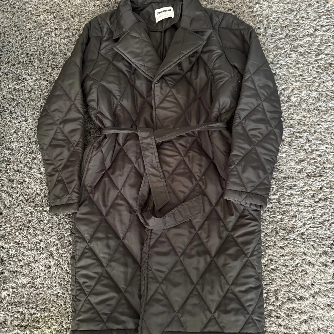 Svart quiltad kappa med bälte - 1