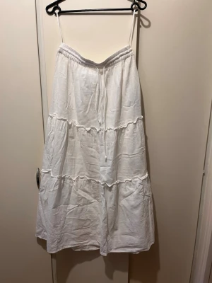 Lång kjol Vila strl 38  - Lång vit kjol från Vila i strl 38. Material: bomull. Något genomskinligt tyg. Mycket fint skick. 