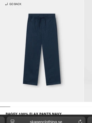 Marinblå linnebyxor med snörning - Säljer ett par marinblå linnebyxor med avslappnad baggy passform och snörning i midjan. Byxorna är raka i benen och har en enkel, stilren look som funkar till många olika outfits. Materialet är 100% linne vilket gör dem luftiga och sköna. Nypris ca 900kr