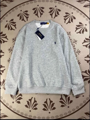 Grå sweatshirt från Polo Ralph Lauren - Snygg grå sweatshirt från Polo Ralph Lauren med klassisk rund hals och broderad logga på bröstet. Tröjan har ribbade muddar vid ärmslut och nederkant, samt en normal passform. Perfekt för chill dagar och enkel att matcha med jeans eller joggers.