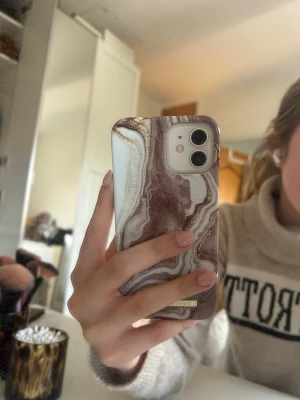 mobilskal från ideal of sweden - Snyggt mobilskal i marmormönster från Ideal of Sweden för iPhone 12/12 Pro. 💕💕 Designen heter Golden Sand Marble. Skalet är oanvänt och säljer eftersom jag fått en ny mobil som skalet inte passar på. Skickas i originalkartong och nypris är 350kr 🩷💞
