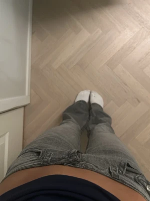 Grå bootcut jeans med fickdetaljer - Säljer ett par grå jeans med bootcut-snitt och låg midja. Jeansen har coola fickor med knappdetaljer både fram och bak, samt klassiska bälteshällor. Materialet är jeans och färgen är en snygg mörkgrå ton som passar till det mesta. Använt de cirka 4 gånger och de är o storlek 164 som passar s🫶