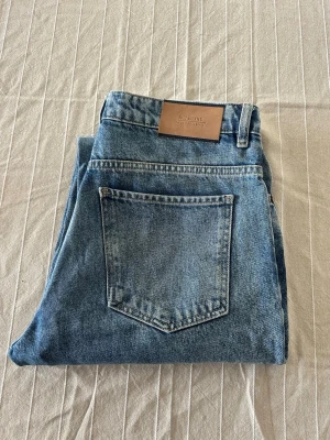 Blå wide jeans från Just Junkies - Säljer ett par blå jeans från Just Junkies med klassisk femficksdesign och råa, fransiga benslut. Jeansen har en rak och wide passform som ger en avslappnad vibe. Tillverkade i slitstark denim med ljus tvätt och tydliga sömmar. Perfekt för dig som gillar streetstyle.